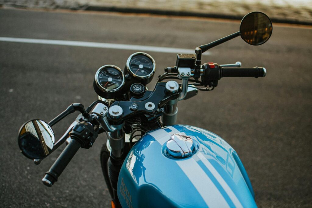 Close-up view of a motorcycle handlebar and dashboard on a road in Curitiba, Brazil.
